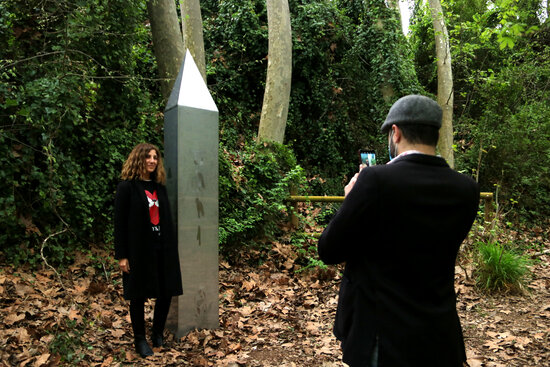 A woman posing for a photo next to the Aiguamúrcia obelisk (by Mar Rovira)